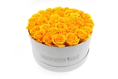 Caja redonda blanca con rosas amarillas eternas